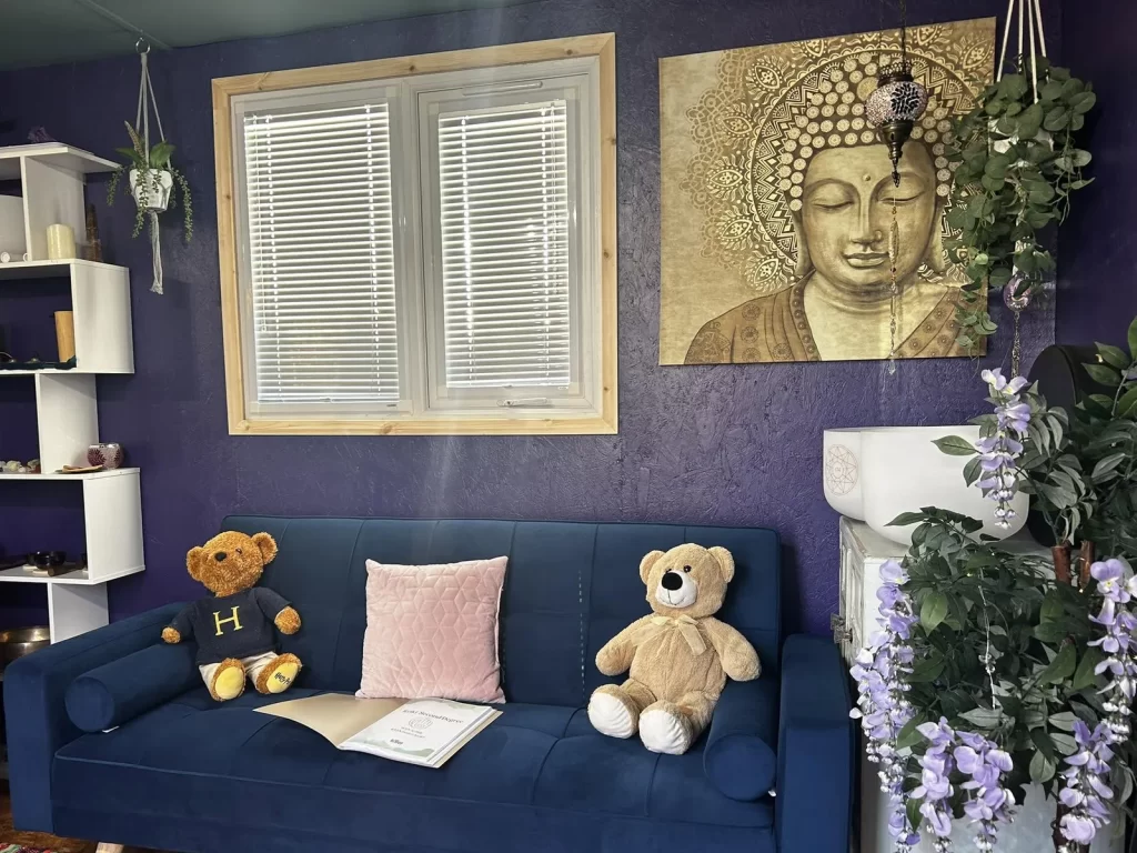 Jo's cosy garden cabin: a navy sofa, golden Buddha artwork, singing bowls and soft wisteria