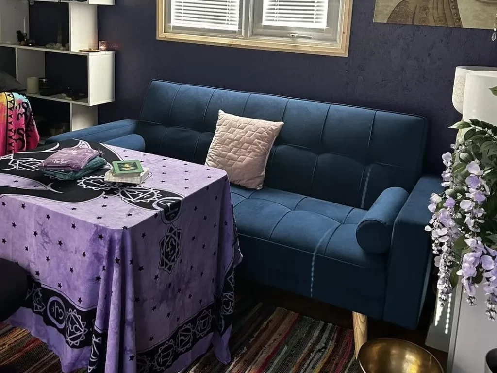 A card-reading table and comfortable sofa inside Jo's cosy cabin